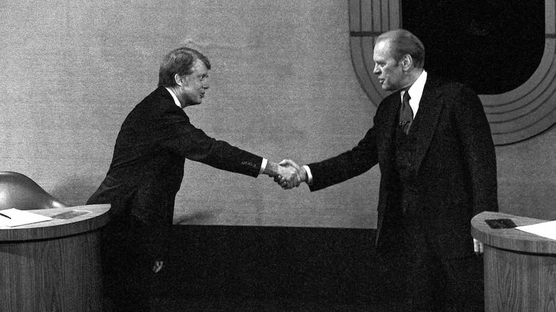 FILE - Jimmy Carter, left, and Gerald Ford, right, shake hands before the third presidential...