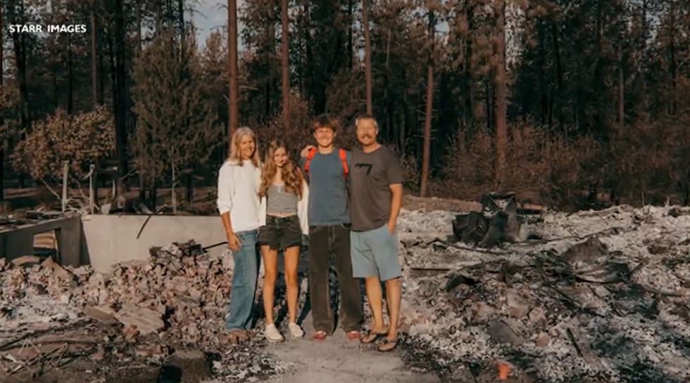 Becks Bird and his family posed for a picture near the remains of their Spokane home.